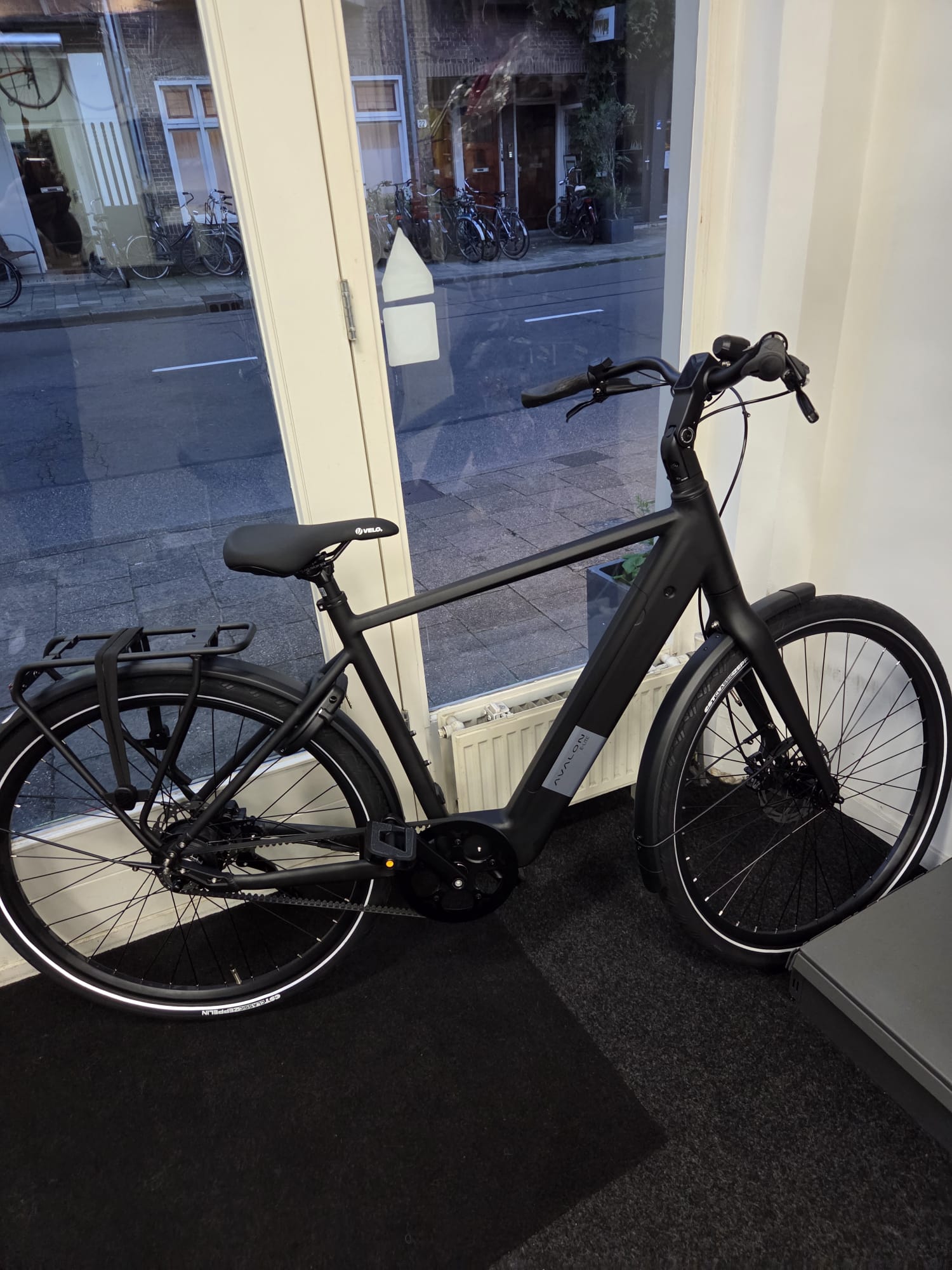 Zwarte Avalon E-Lite elektrische stadsfiets in de winkel, van opzij